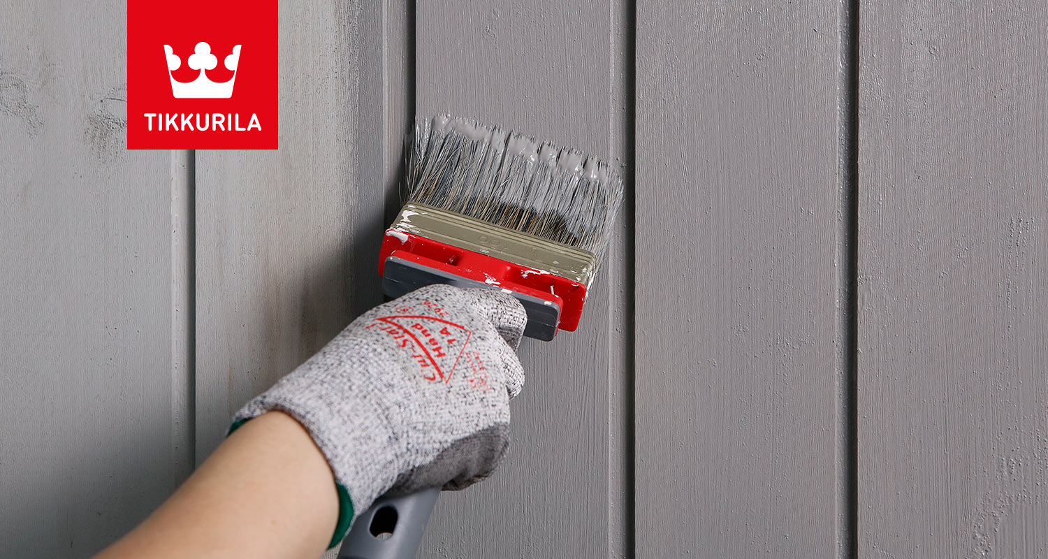 Maalari maalaa harmaaksi sävytetyllä Tikkurilan Ultra Classic -talomaalilla puutalon ulkoseinää. Tuote myynnissä K-Raudassa. 
