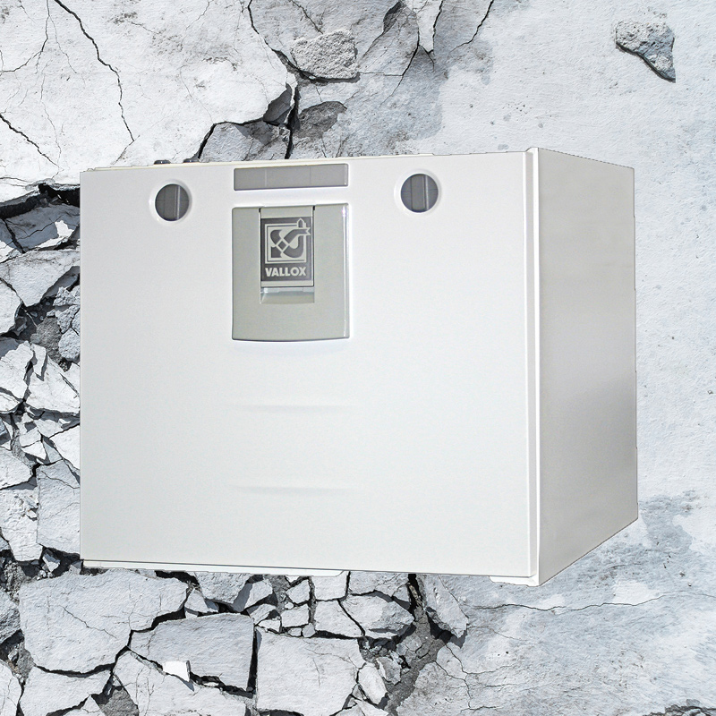 Valkoinen Vallox-ilmanvaihtokone harmaalla halkeilleella betoniseinällä