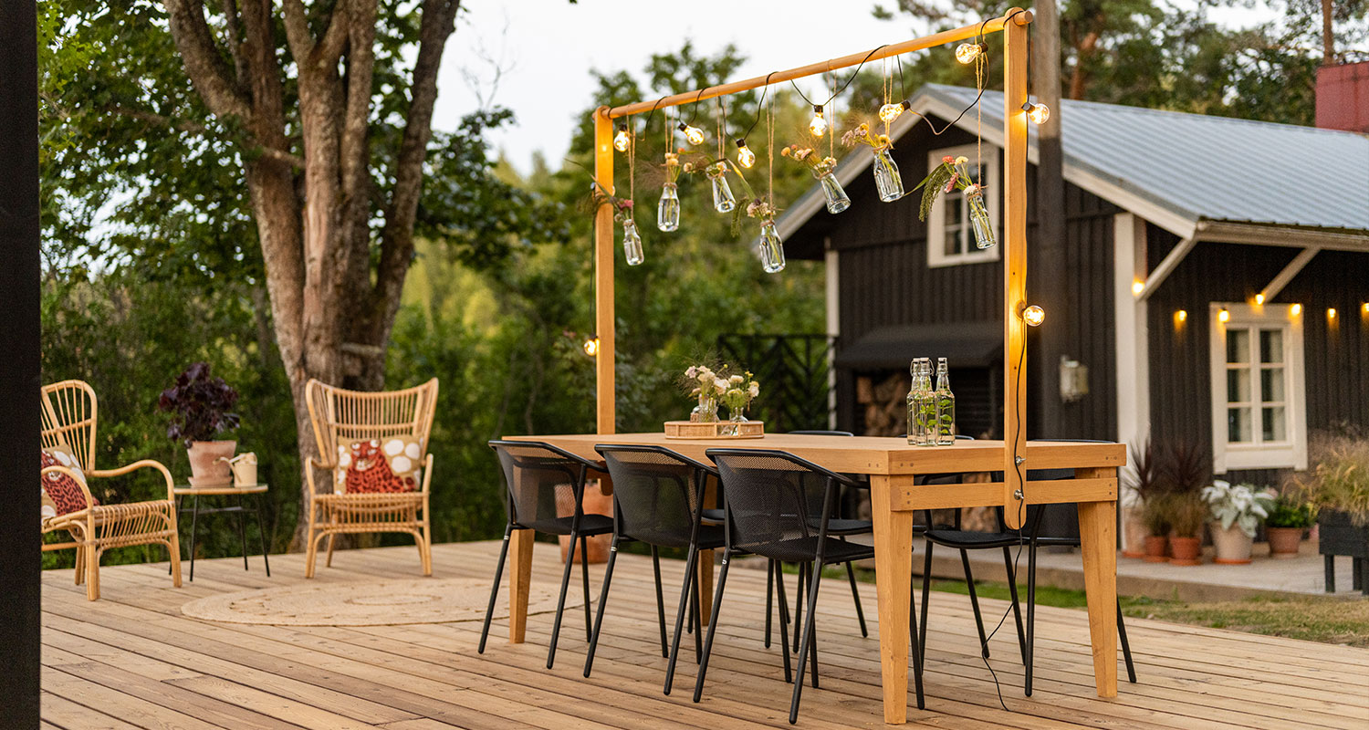 Puutarhapöytä koristetelineellä kesäkeittiön terassilla