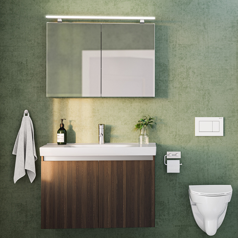 Vihreä kylpyhuone: led-peilikaappi, puinen allaskaappi valkoisella altaalla, kasvi ja seinä-wc.