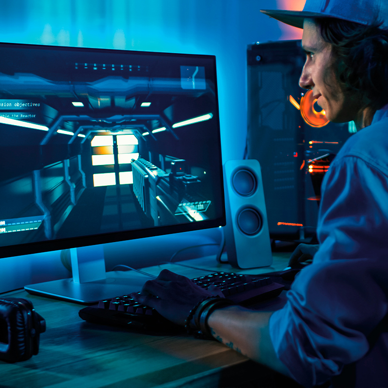 Gaming-valaistus. Kuvassa mies pelaamassa tietokoneella.