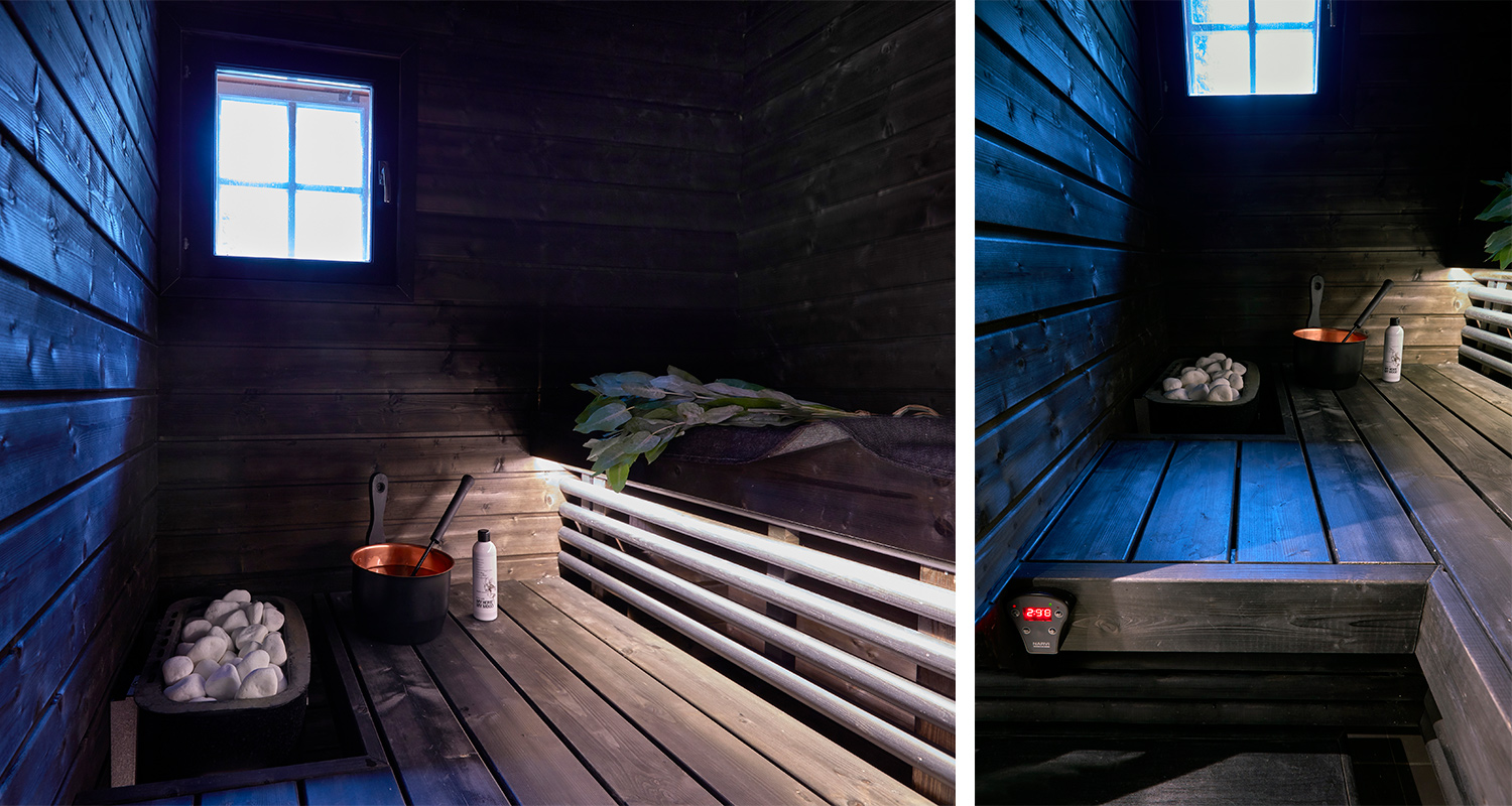 Tumma puusauna sinisessä ikkunavalossa, puiset penkit, kiuas kivillä, löylykiulu ja vihta.