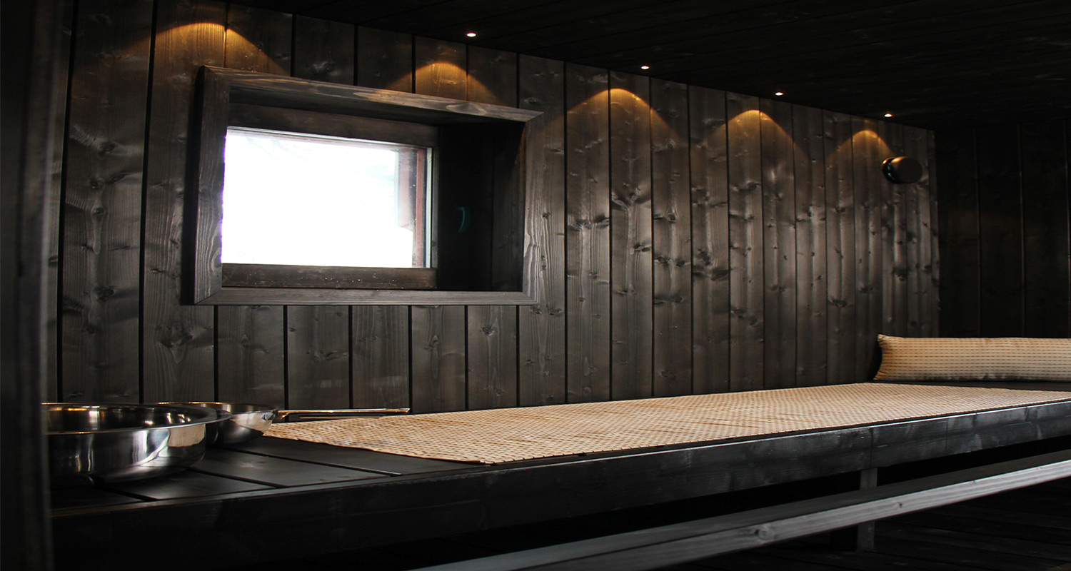 Huvila & Huussi -ohjelmassa K-Raudan avulla mökkisauna. Kuvassa tumma ja tunnelmallinen mökkisauna rakennettuna Cellon tuotteilla.