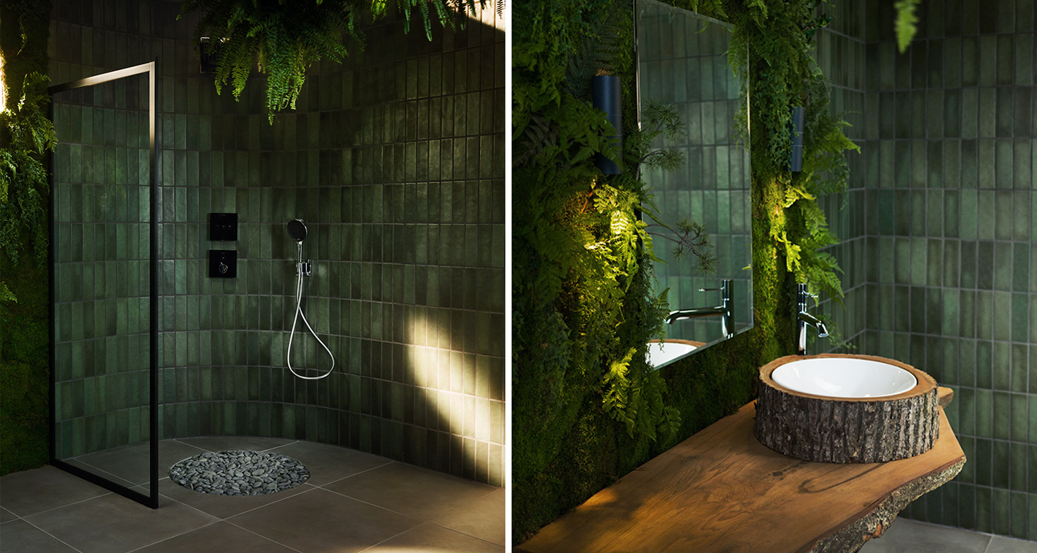 Vihreä laatoitus saniaisseinät, musta lasisuihku vasemmalla, puuallas valkoisella kulholla oikealla.