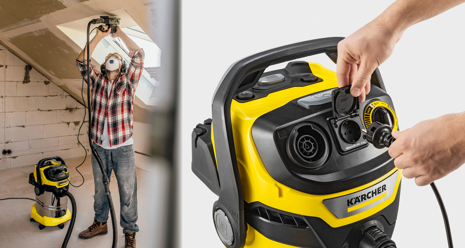 Mies suojavarustein hioo katon, vieressä keltamusta Kärcher-työimuri, käsi kytkee johdon.
