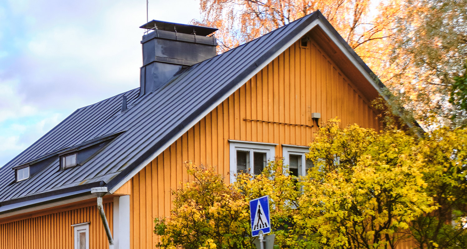 Vanhan omakotitalon keltainen julkisivu.