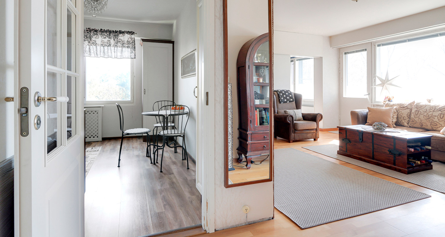 Vanha keittiö ennen remonttia keittiön ulkopuolta kuvattuna, vieressä näkyy olohuone.