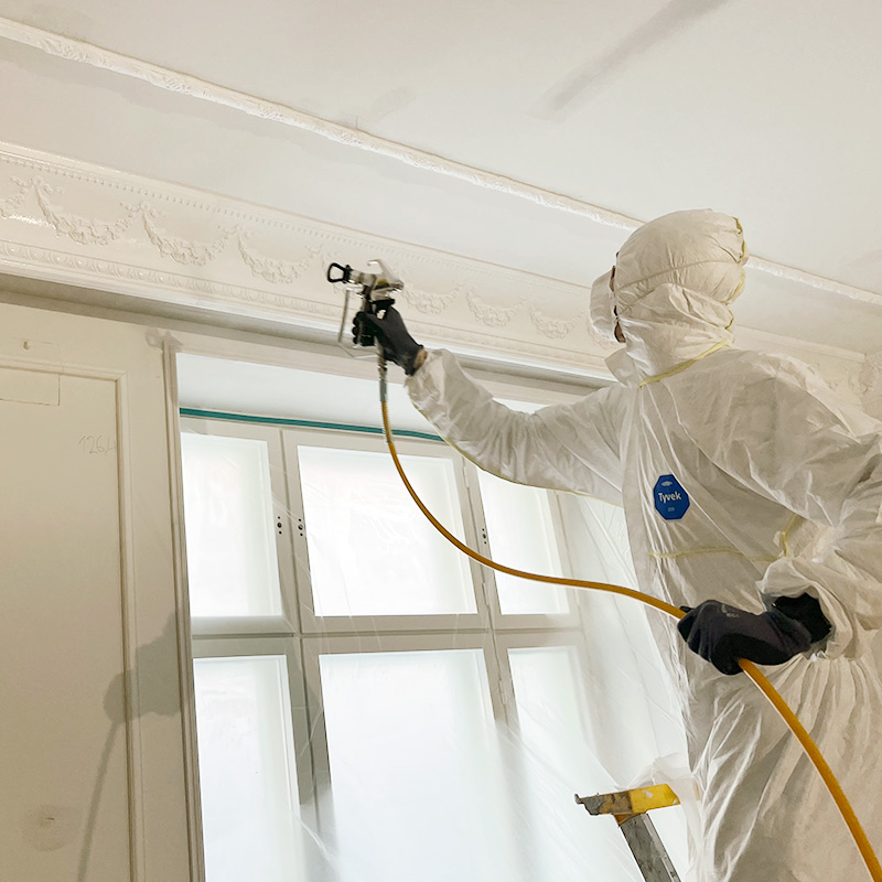 Kuvassa käynnissä huoneiston laipioiden ja koristelistojen pintamaalaus kalvoruisku Wagner SF 21 Pro HEA -laitetta hyödyntäen. 