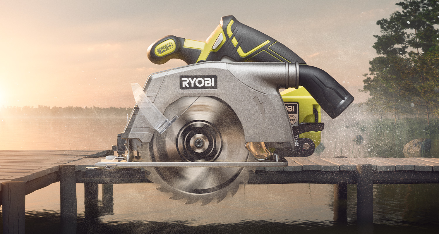 Vihreä-musta Ryobi-pyörösaha pyörivällä terällä laiturilla järven rannalla auringonlaskussa