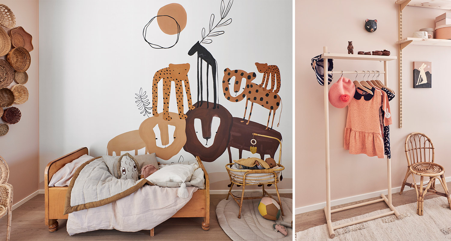 Vaaleanpunaisessa lastenhuoneessa puusänky, korikehto, eläinmuuraali, vaateräkki ja rottinkituoli