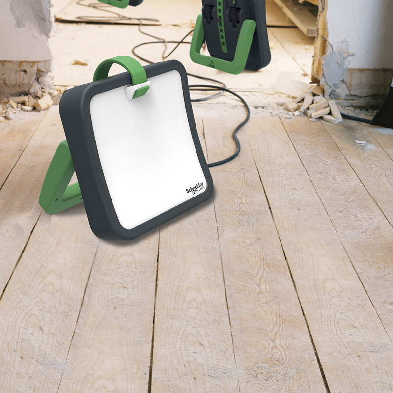 Sisärakennustyömaalla puulattialla mustavihreä Schneider Electricin LED-työvalo.