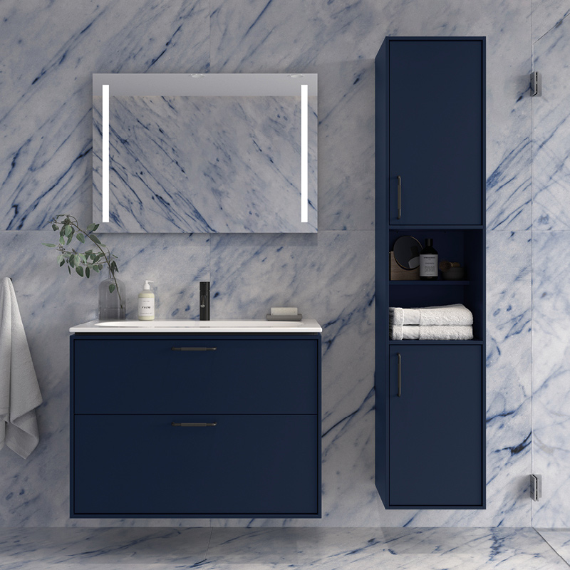 Sinimusta pesuallas ja korkea kaappi marmoriseinällä, valaistu peili, pyyhkeet ja kasvi