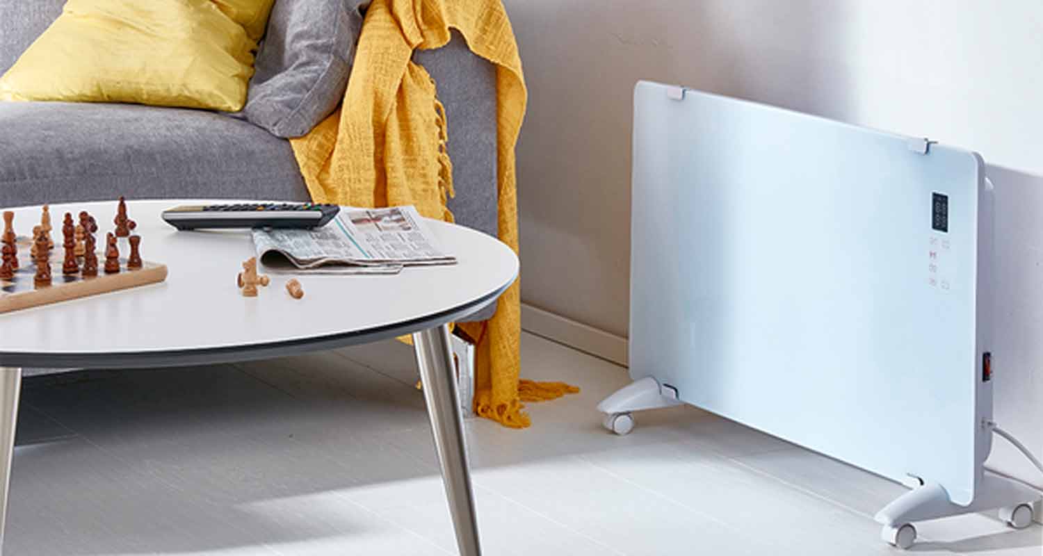 Harmaa sohva keltaisella tyynyllä, valkoinen pöytä shakkilaudalla ja lämmitin pyörillä.