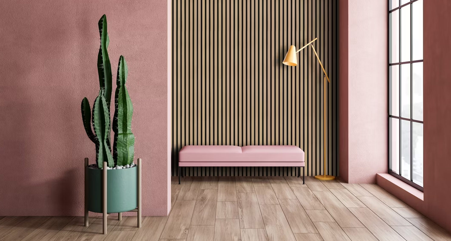 Vihreä kaktus pinkissä huoneessa puurimoitetta vasten, vaaleanpunainen penkki ja kultalamppu