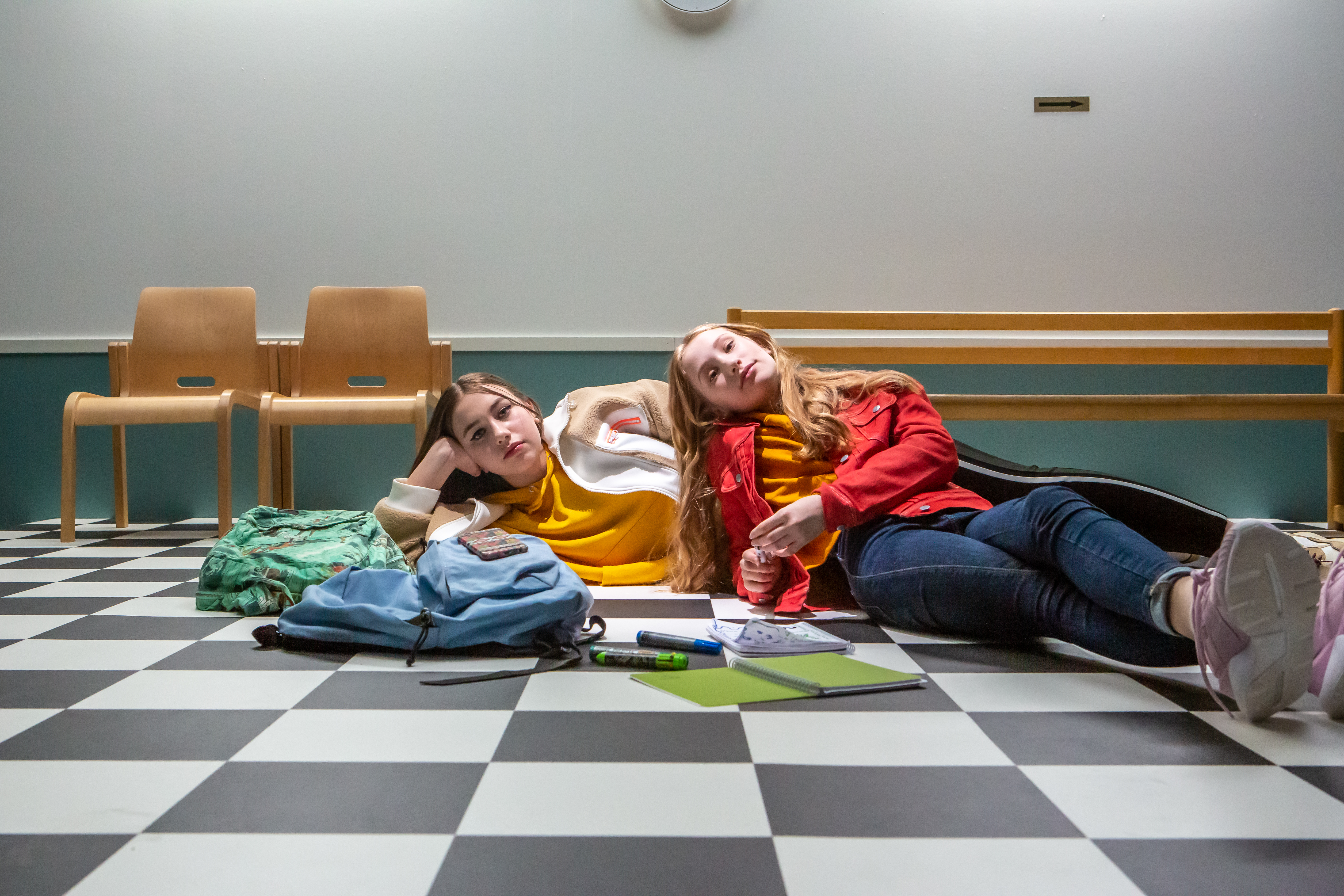 Koululaiset makoilevat koulun lattialla