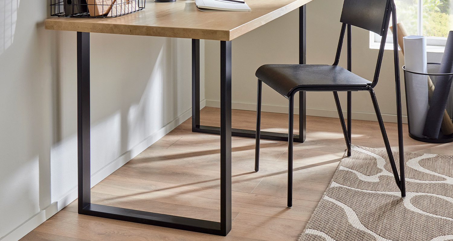 Mustat kalustejalat puisessa työpöydässä. Katso vinkit kalustejalkojen valintaan.