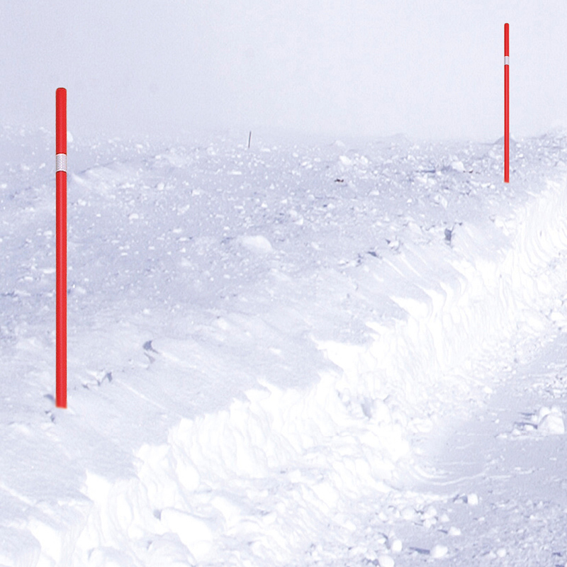 Kuvassa lunta ja lumessa on pystyssä kaksi punaoranssia aurausviittaa.