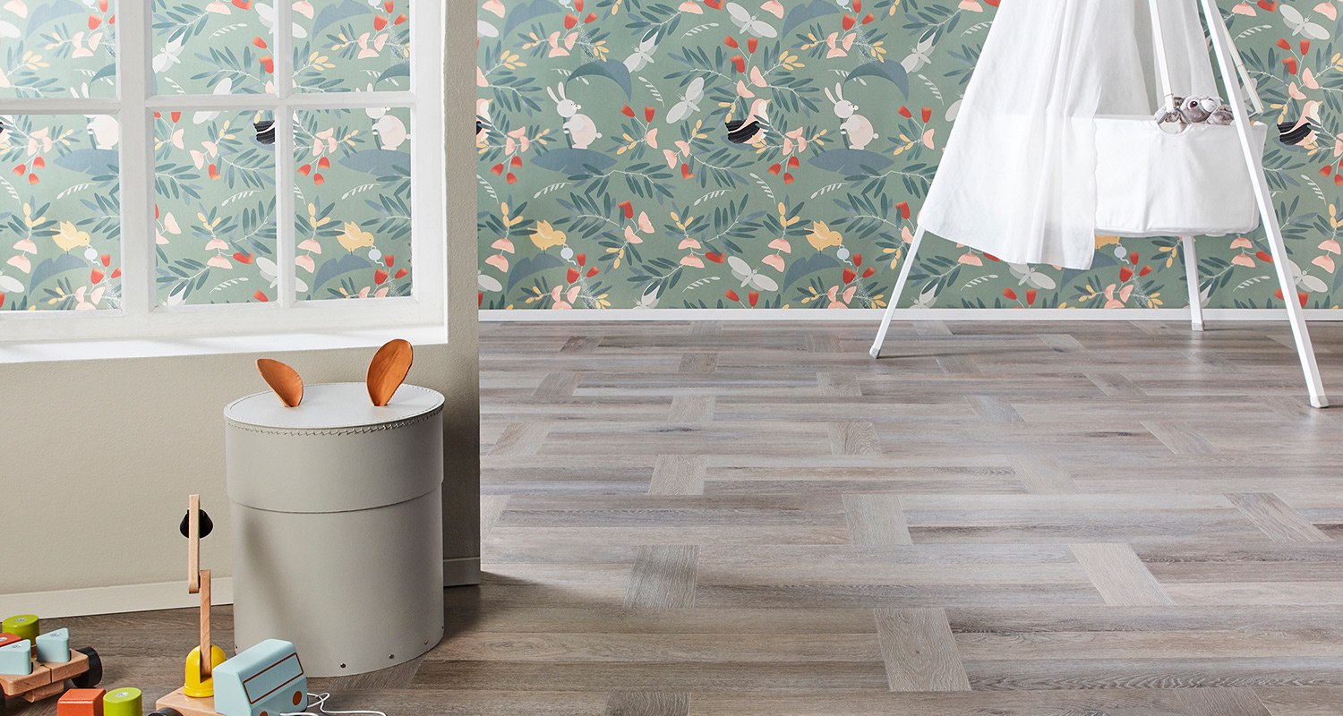 Lastenhuone: mintunvihreä pupu-lehtitapetti, vaalea lattia ja harmaa rahi nahkakorvilla.