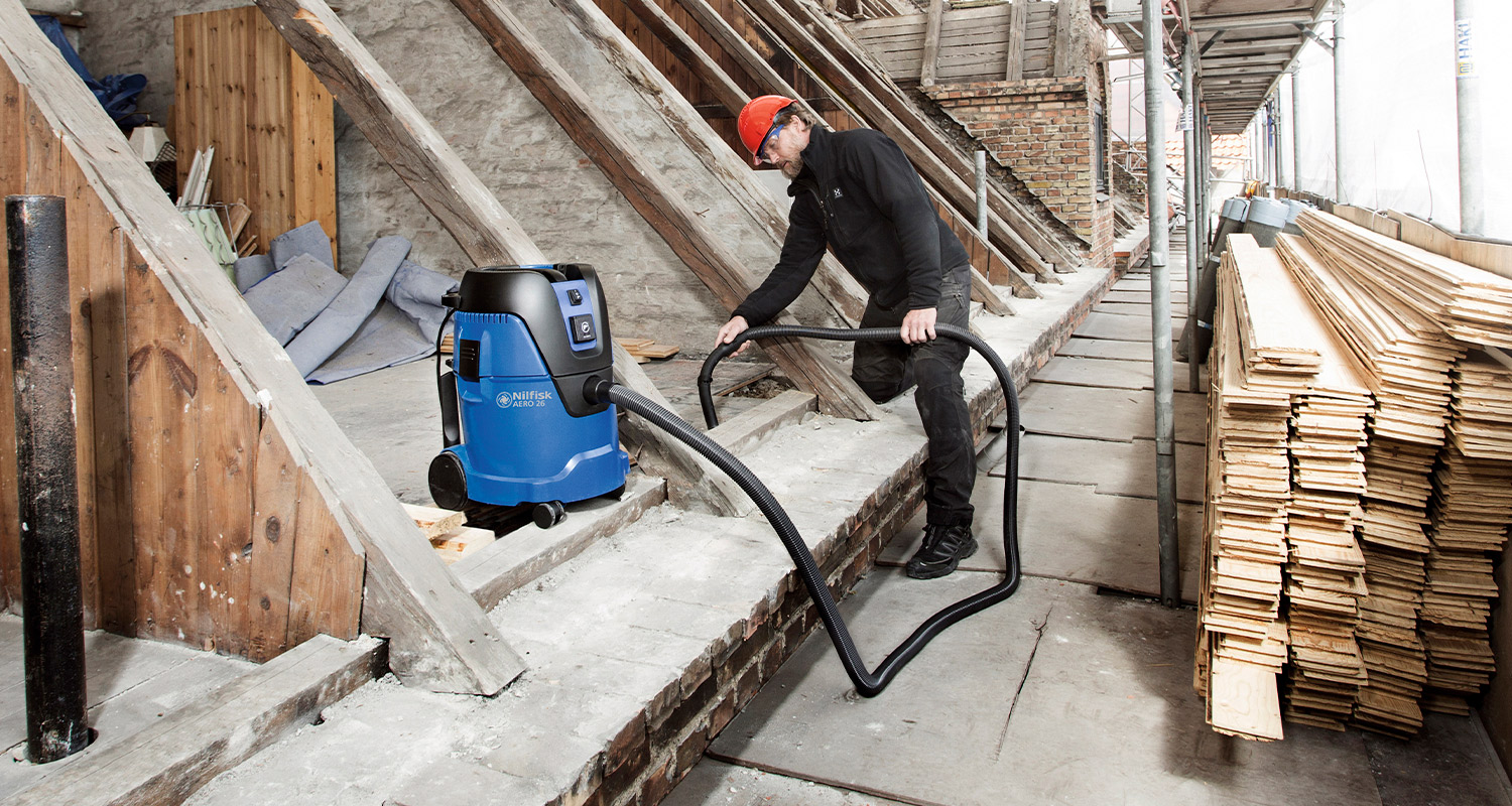 Mies työmaalla käyttämässä märkä-kuivaimuri Nilfisk Aero 6-2L PC