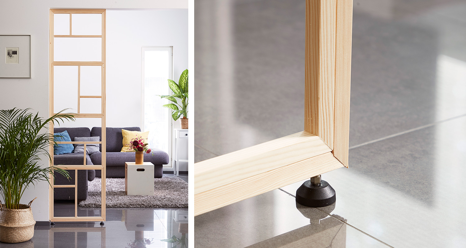 Valoisa olohuone, vaalea puinen ruudukkoerotin, harmaa sohva värikkäillä tyynyillä, viherkasveja.