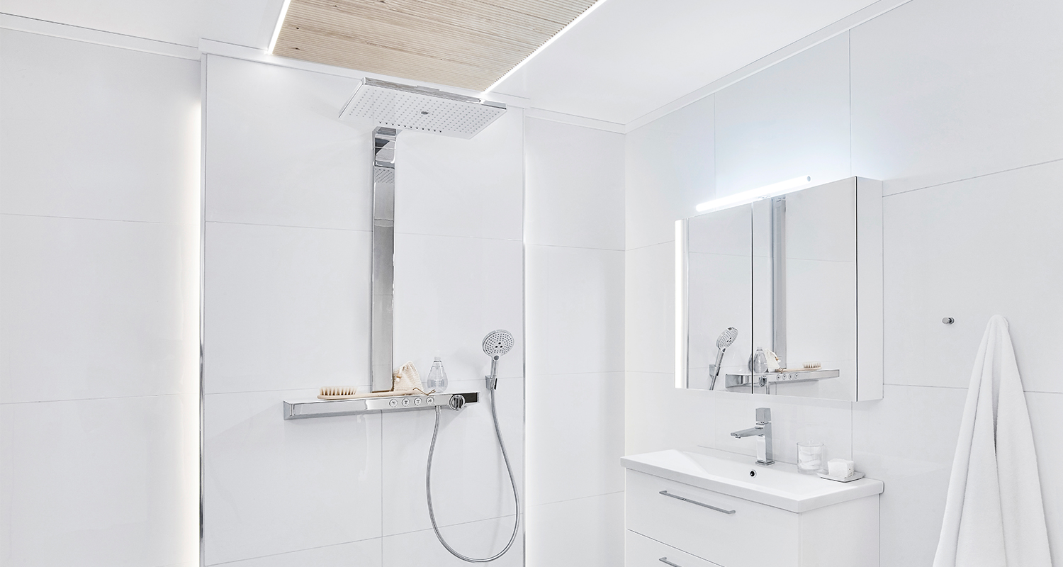 Moderni valkoinen kylpyhuone: kromattu sateen- ja käsisuihku, peilikaappi ja pyyhe.