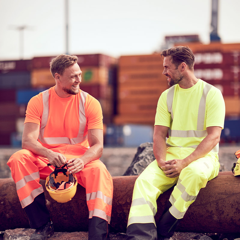 Työmiehillä päällä näkyvät hi-vis t-paidat ja työhousut oranssina ja keltaisina. Kyseiset työvaatteet ovat PROF-mallistoa K-Raudasta.
