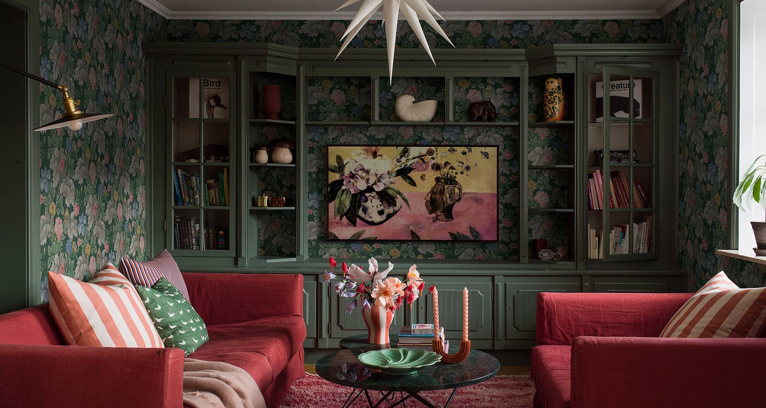 Kuvan olohuoneen seinässä näkyy kaunis luontoaiheinen Boråstapeter New Heritage 4834 -kuitutapetti, jota myy K-Rauta. Kuvan edustalla punainen sohva ja nojatuoli.
