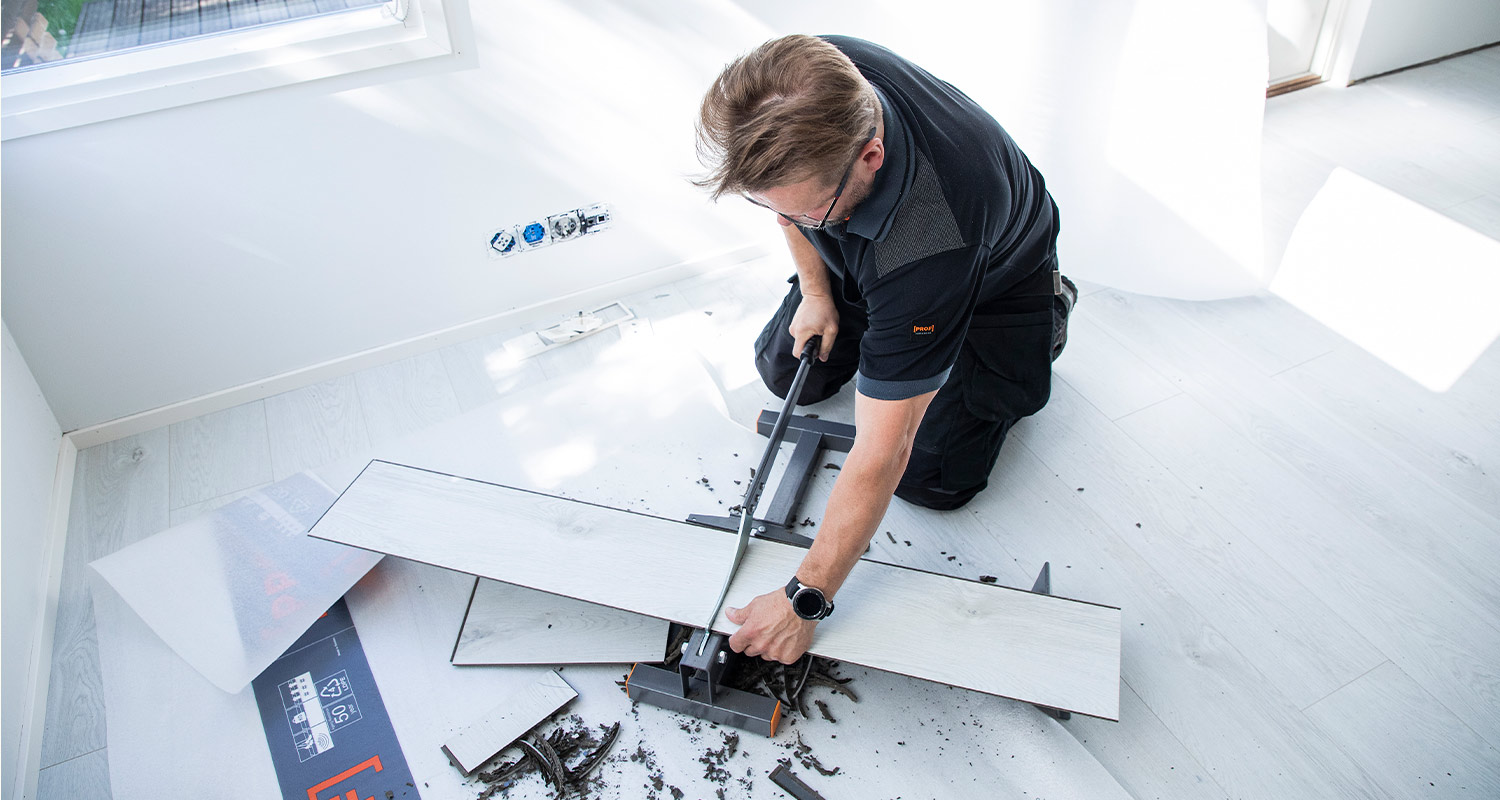 Mies tekemässä lattiaremonttia.