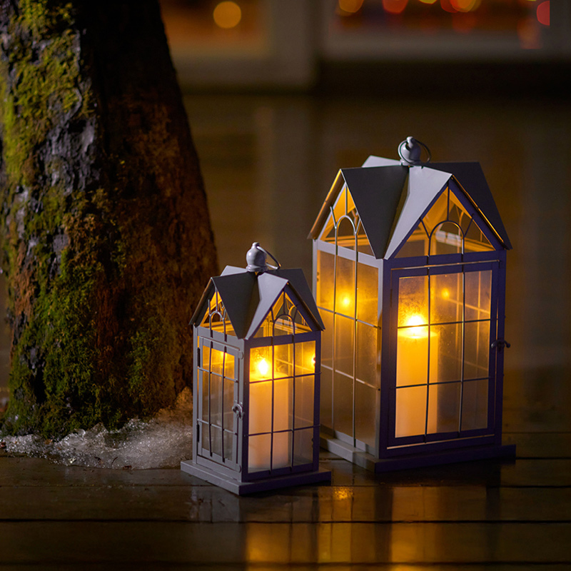 Kuvassa kaksi talon mallista lyhtyä.