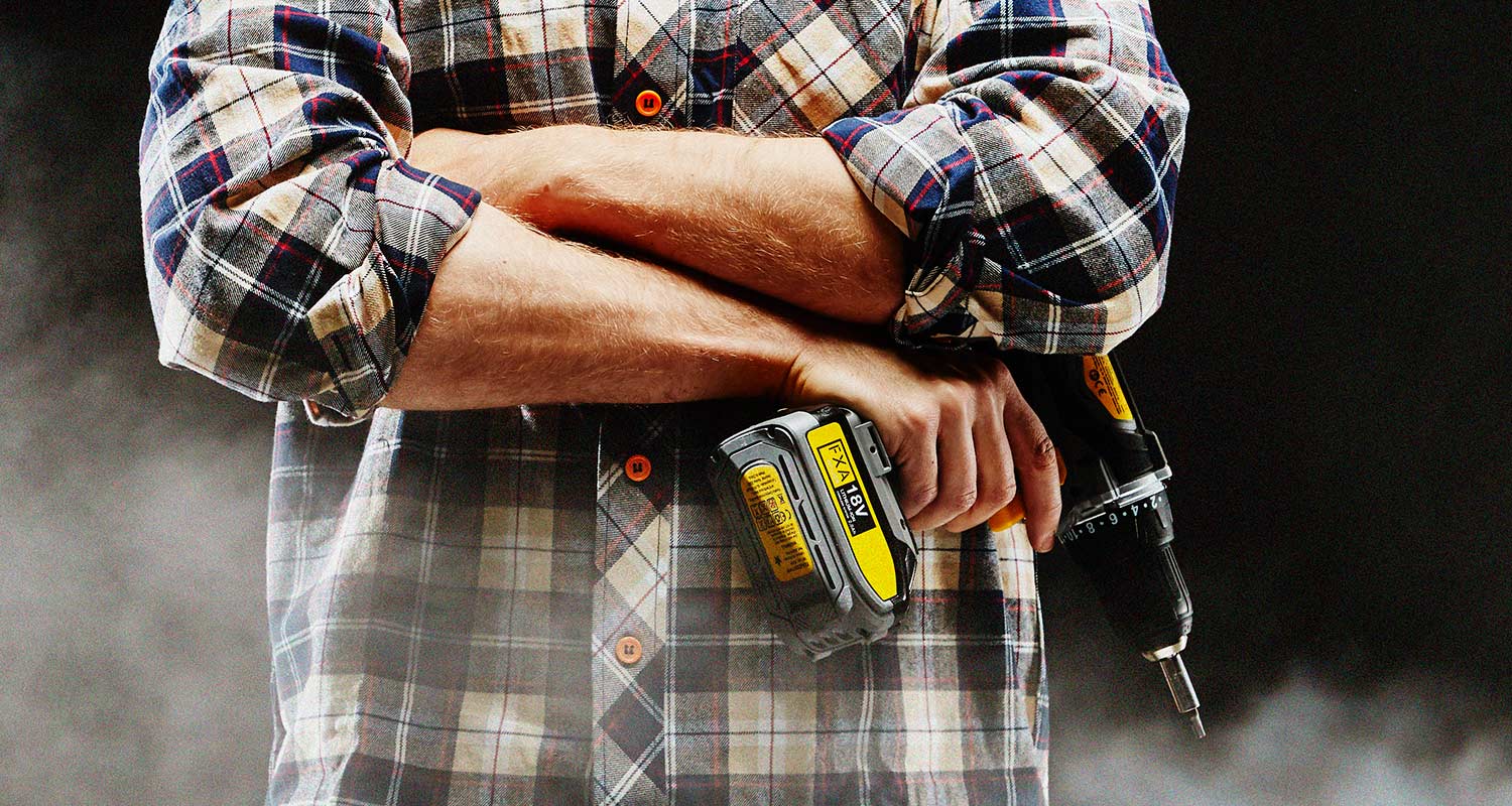 Mies FXA-akkuporakoneen kanssa, merkkiä myynnissä K-Raudassa