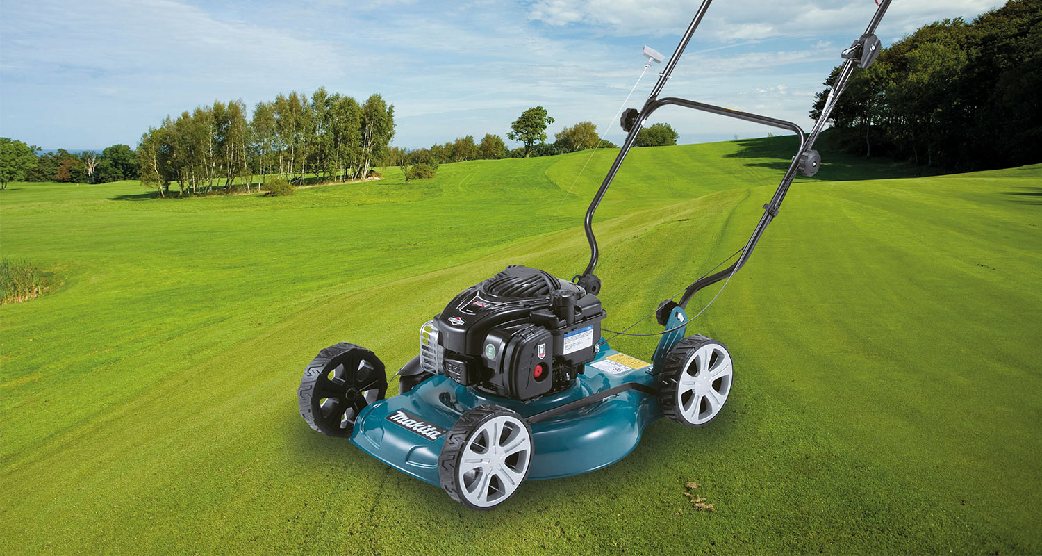 Sinivihreä-musta Makita-ruohonleikkuri avaralla nurmikentällä, puuryhmä ja sininen taivas taustalla