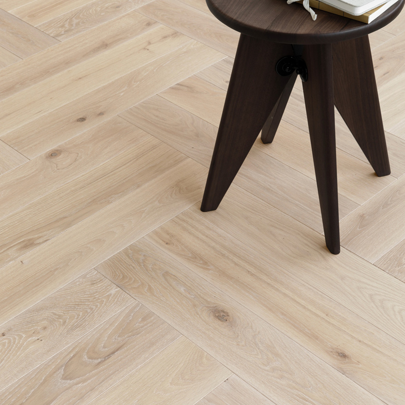 Kuvassa lankkuparkettia vaaleassa sävyssä sekä tumman ruskea tuoli.