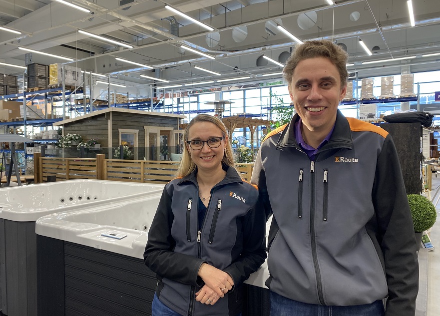 K-Rauta-univormuun pukeutuvat myyjät seisovat valkoisen porealtaan edessä rautakaupassa.