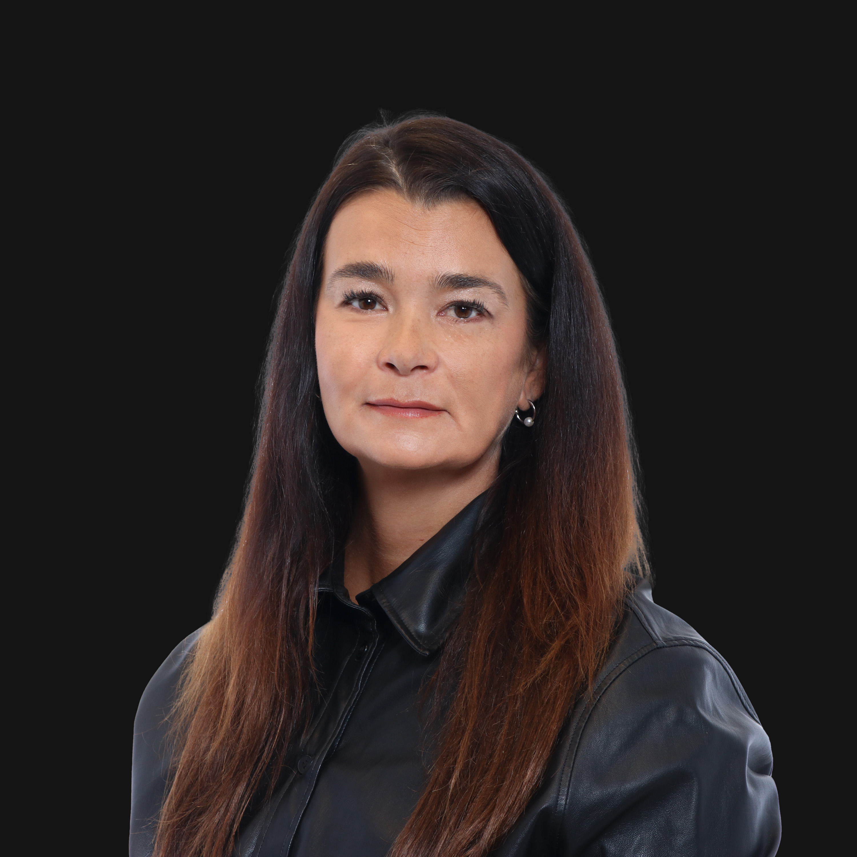 Pitkä ruskeatukka ja musta nahkatakki tummalla taustalla