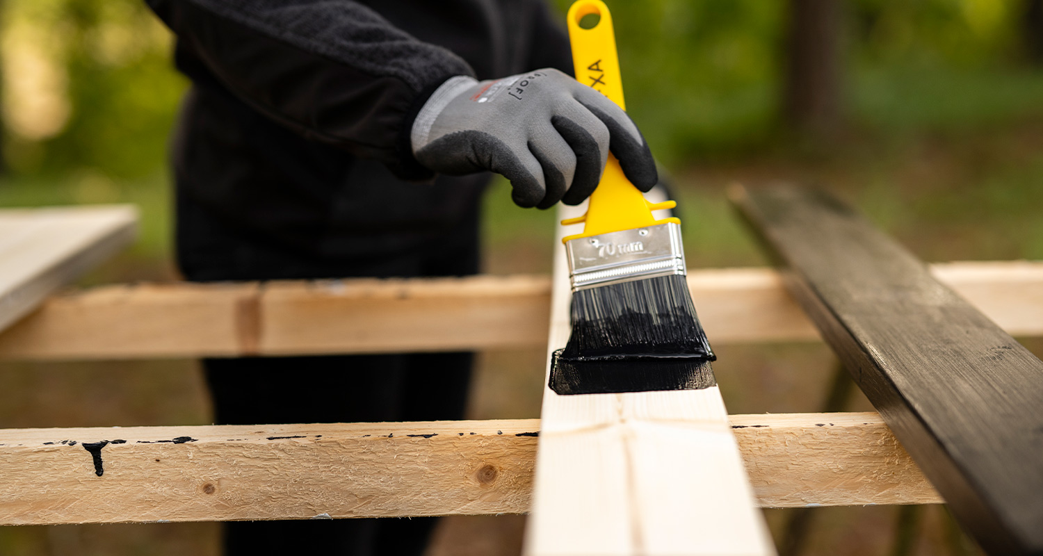 Tee itse terassikaide: Mies maalaa pystypuita