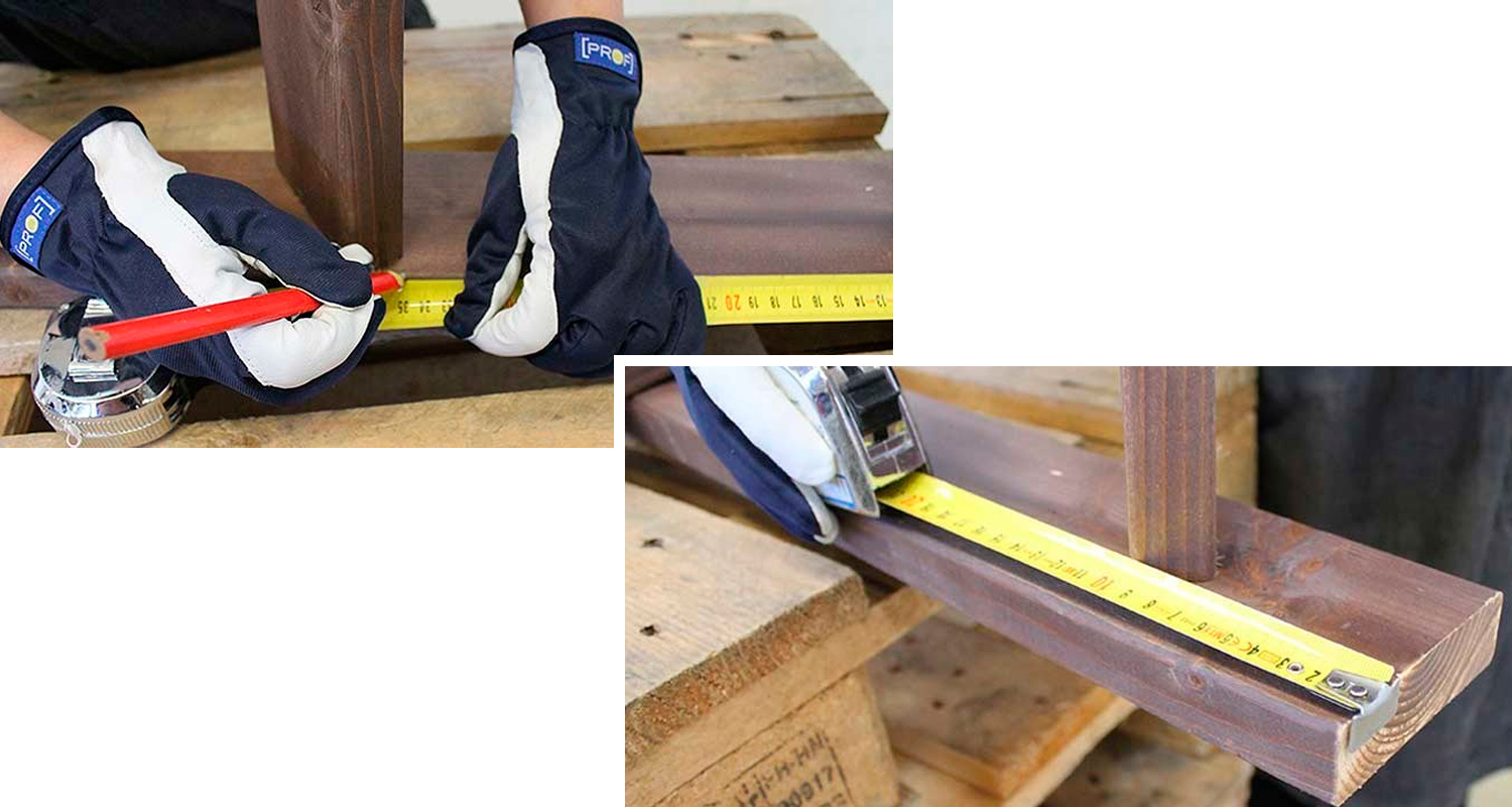 Sinivalkoiset työkäsineet pitelevät keltaista mittanauhaa ruskean puulistan päällä