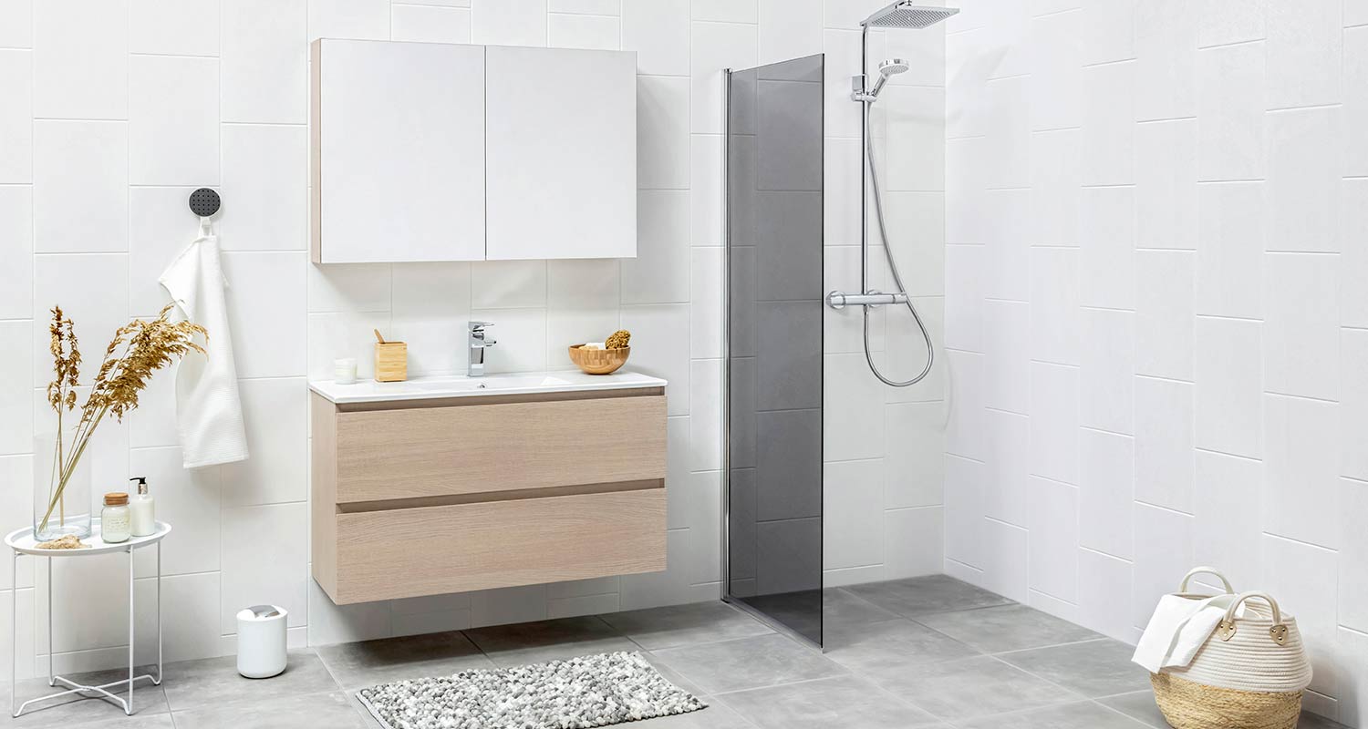 Valkoiset laatat, vaalea puuallas, harmaa lattia ja minimalistinen lasisuihku