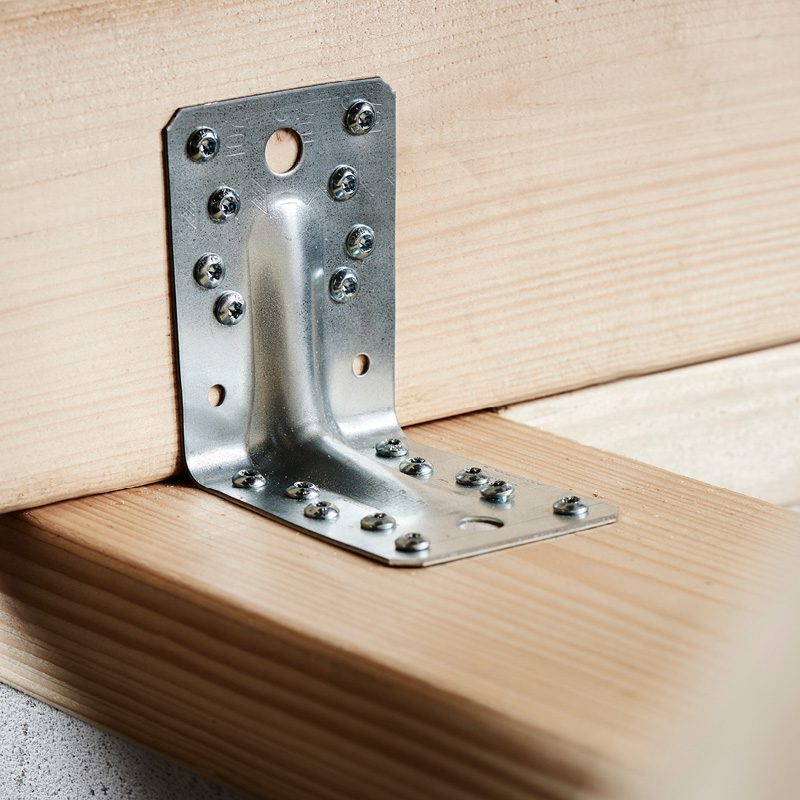 L-muotoinen teräskulma usealla ruuvilla kiinnitetty vaaleaan puuhun.