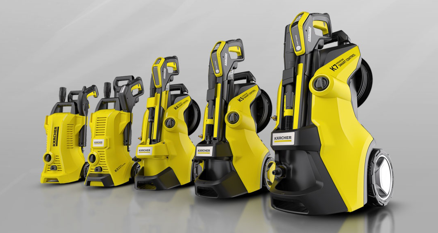 Viisi erikokoista keltamustaa Kärcher-painepesuria rivissä harmaata taustaa vasten.
