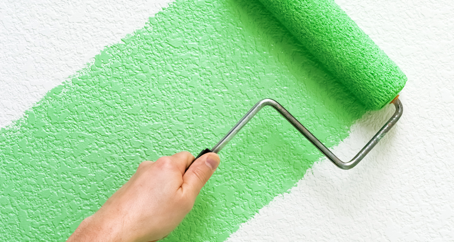 Vihreää maalia telataan seinään.