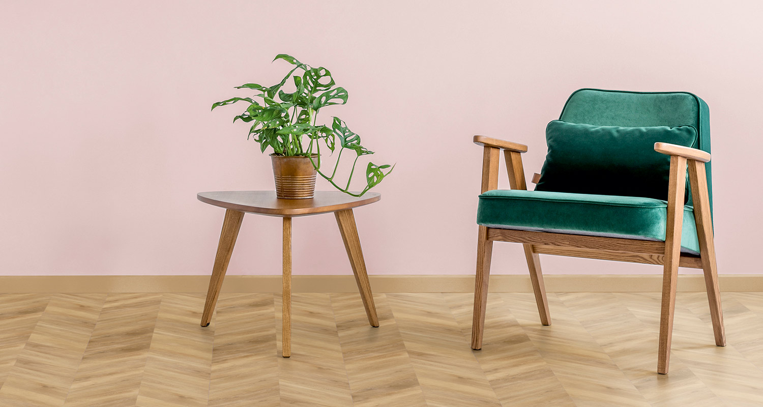 vaalean puunvärinen kalanruoto vinyylilankku lattiassa ja vaaleanpunainen seinä