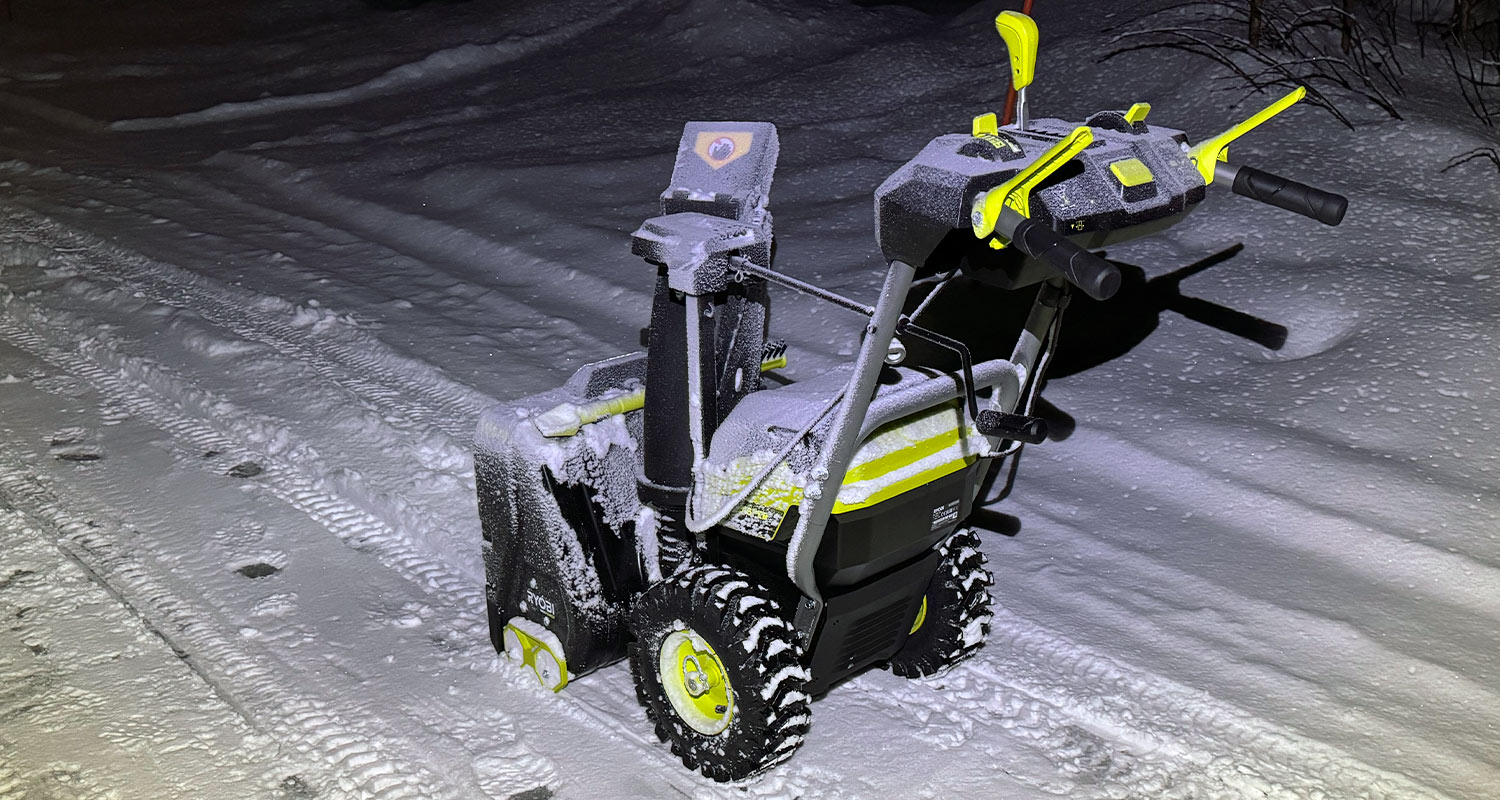 Kuvassa lumisella omakotitalon ajoväylällä akkulumilinko Ryobi RY36STX56A-250 36V Max Power, joka löytyy K-Raudan valikoimista. 