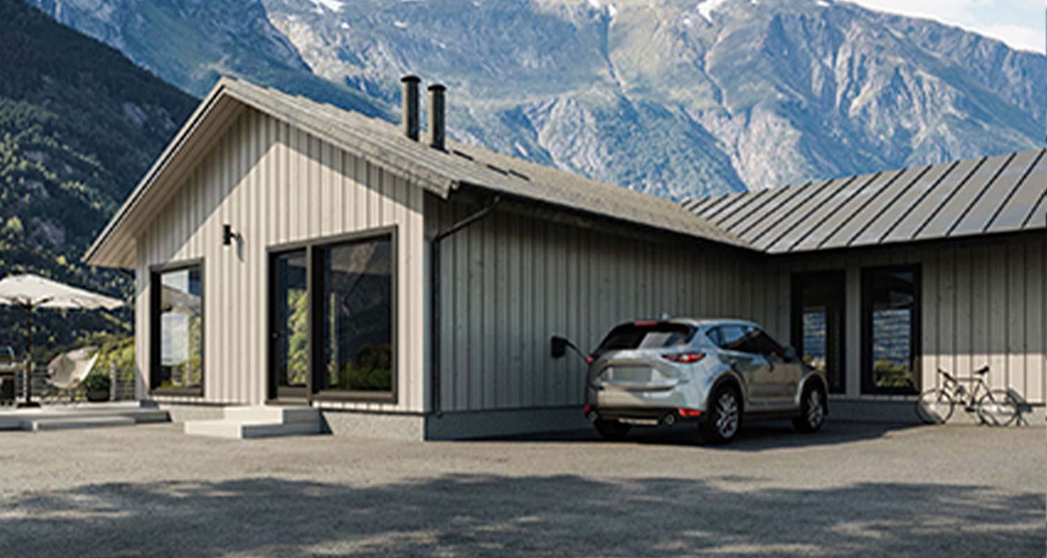Vaalea moderni puutalo vuoristomaisemassa, harmaa sähköauto latautumassa autopaikalla ja polkupyörä