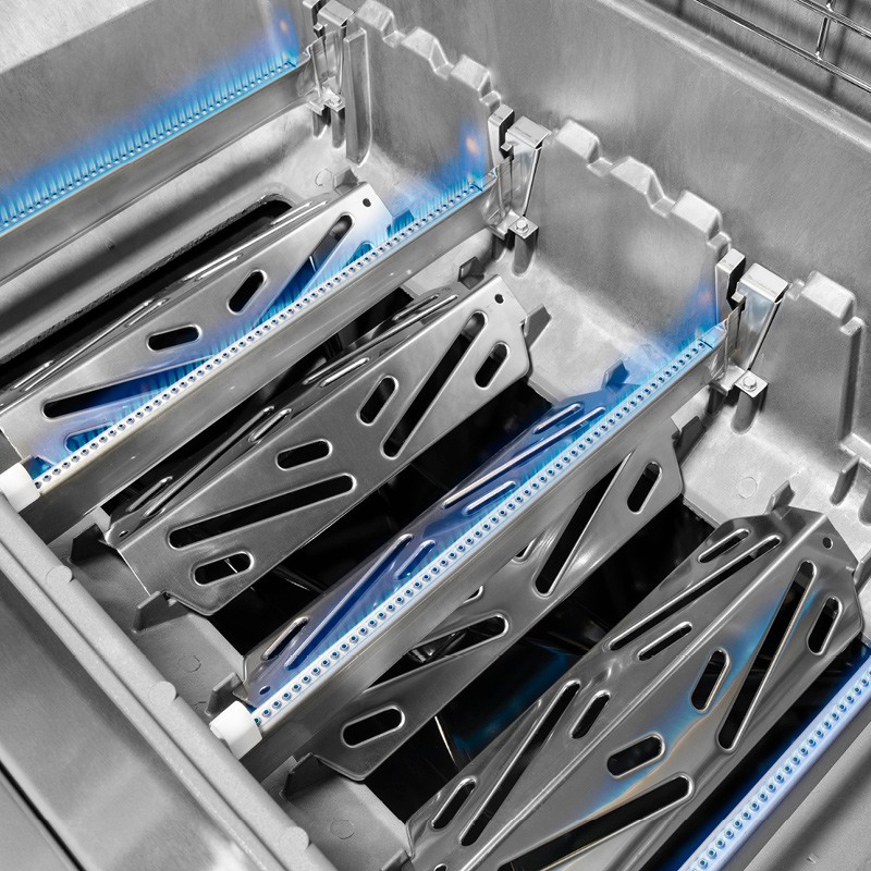 Astianpesukoneen sisällä kulmikkaat harmaat metalliristikot ja siniset vesisuihkut.