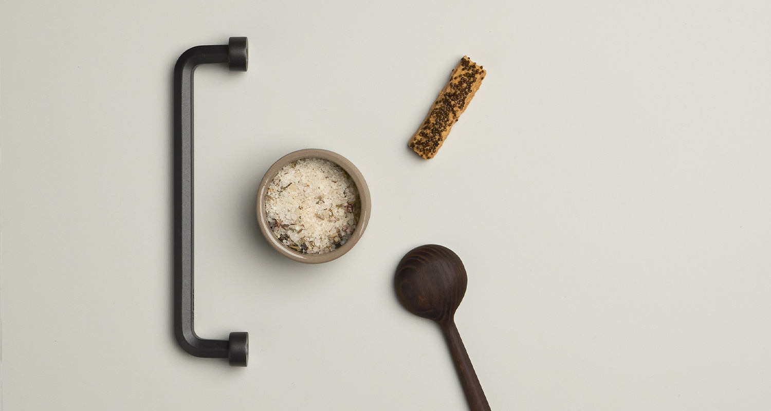 Cello-keittiö moodboard, jossa musta vedin ja keittiötarvikkeita.