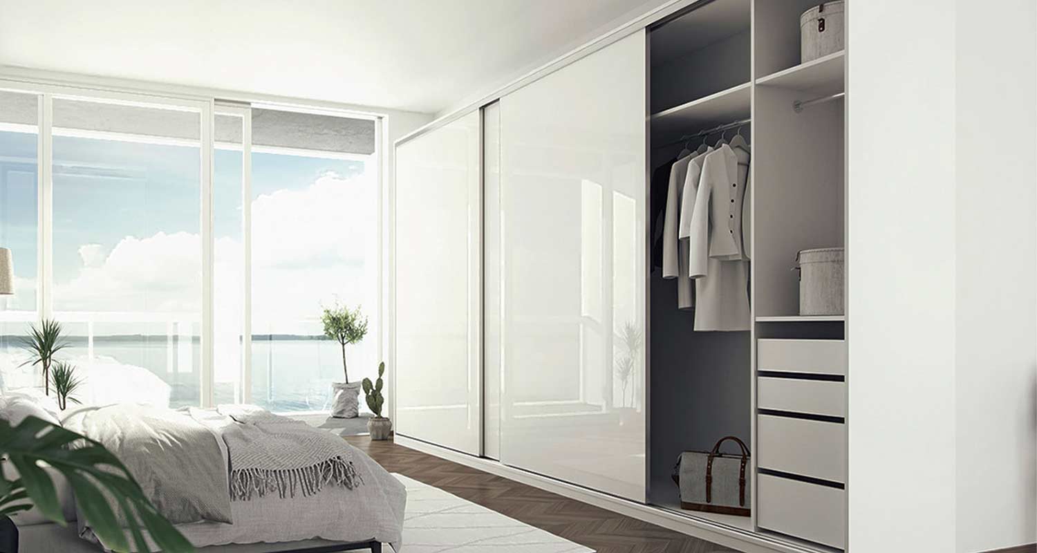 Vaalea makuuhuone valkoisin liukuovikaappein ja merinäkymä isosta ikkunasta