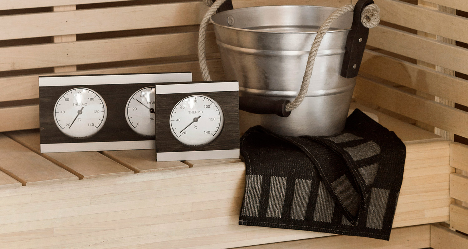 Cellon saunamittari, löylykiulu ja pellavainen musta pefletti vaalean saunanlauteilla K-Raudasta. 