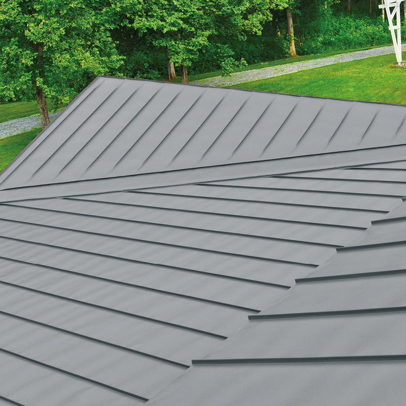 Kuvassa peltikatto, joka maalattu mustaksi peltikattomaalilla. Kuvassa on kesä, koska näkyy vihreää nurmikkoa sekä puissa lehtiä.