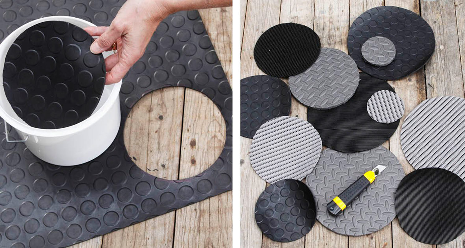 Käsin irrotettu musta kumimatto, puulattialla harmaita ja mustia kumikiekkoja sekä mattoveitsi.