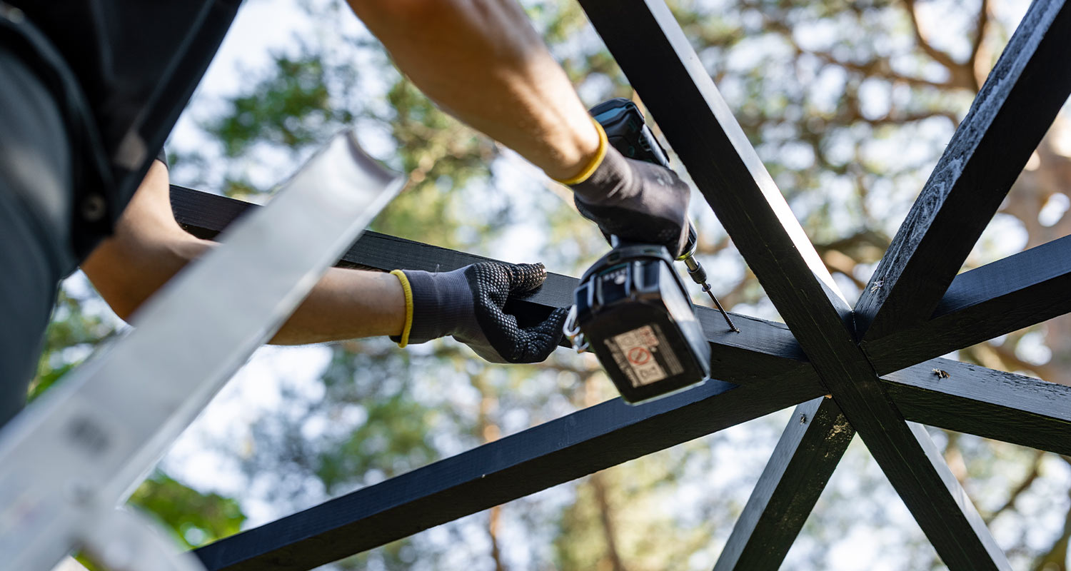 Modernin pergolan rakentaminen. Kuvassa kattoristikon kiinnitys.